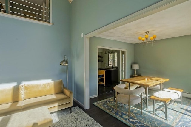 dining area with baseboards, an inviting chandelier, and wood finished floors