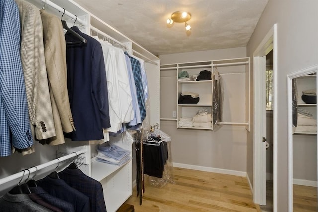 walk in closet with wood finished floors
