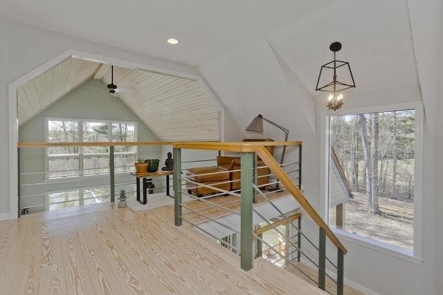 bonus room with lofted ceiling and an inviting chandelier