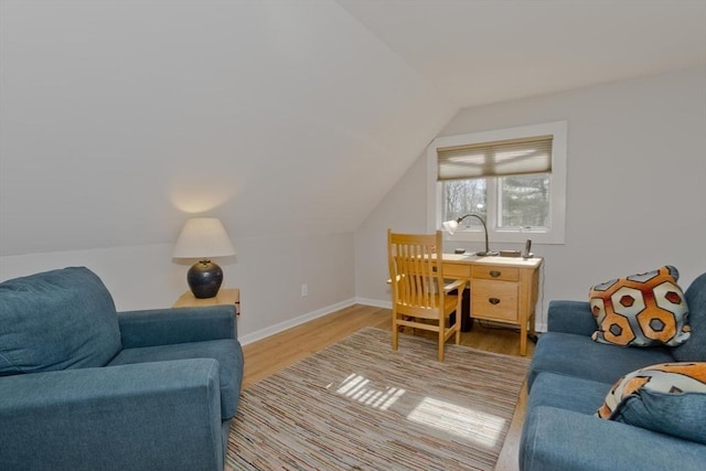 interior space with lofted ceiling, baseboards, and wood finished floors