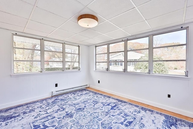 unfurnished room featuring a paneled ceiling and baseboard heating