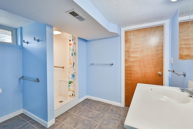 bathroom with a shower with shower curtain, tile patterned flooring, and sink