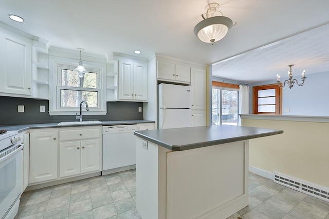 kitchen with sink, white appliances, white cabinets, and a kitchen island