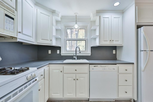 kitchen featuring sink, white appliances, hanging light fixtures, and white cabinets