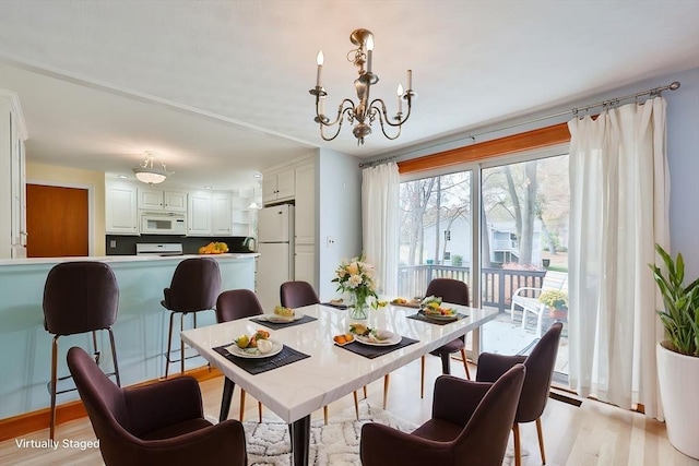 dining area featuring an inviting chandelier and light hardwood / wood-style flooring