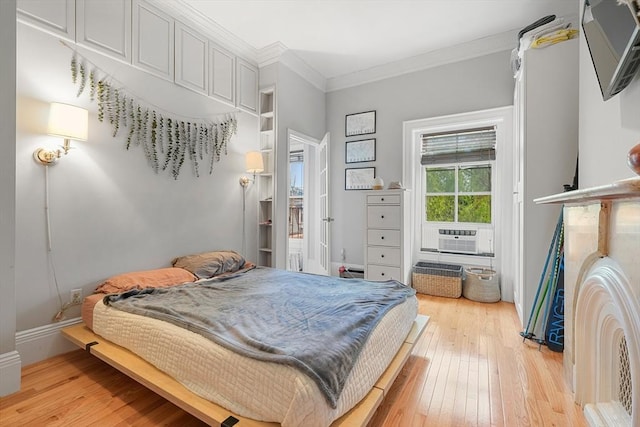 bedroom featuring light wood-type flooring, cooling unit, crown molding, and baseboards