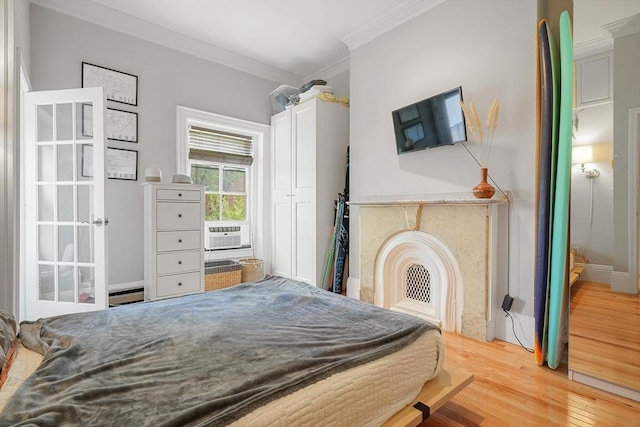 bedroom with crown molding, wood finished floors, and cooling unit