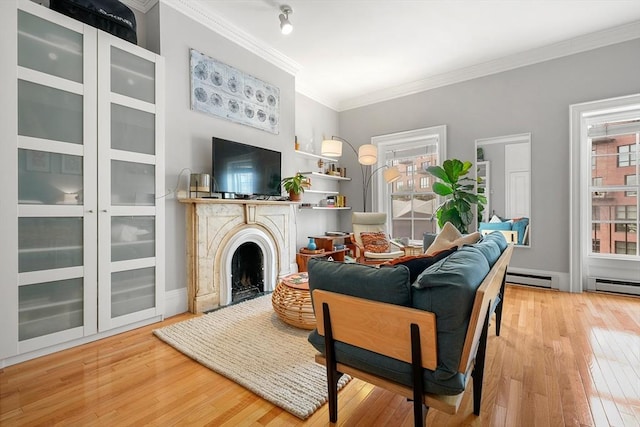 living room with healthy amount of natural light, wood finished floors, crown molding, and baseboard heating