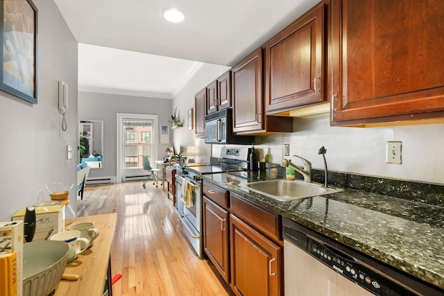 kitchen featuring stainless steel appliances, a sink, light wood-style floors, crown molding, and a baseboard heating unit