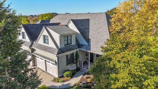 view of home's exterior with a garage, roof with shingles, and driveway