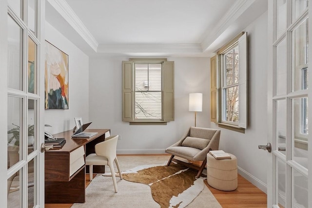 home office with a raised ceiling, plenty of natural light, and wood finished floors