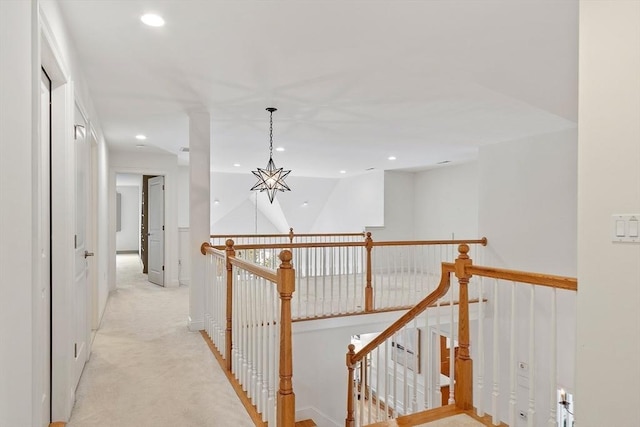 hall with recessed lighting, a chandelier, light colored carpet, and an upstairs landing