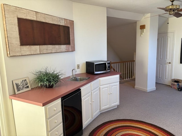 kitchen with sink, ceiling fan, refrigerator, white cabinetry, and light colored carpet