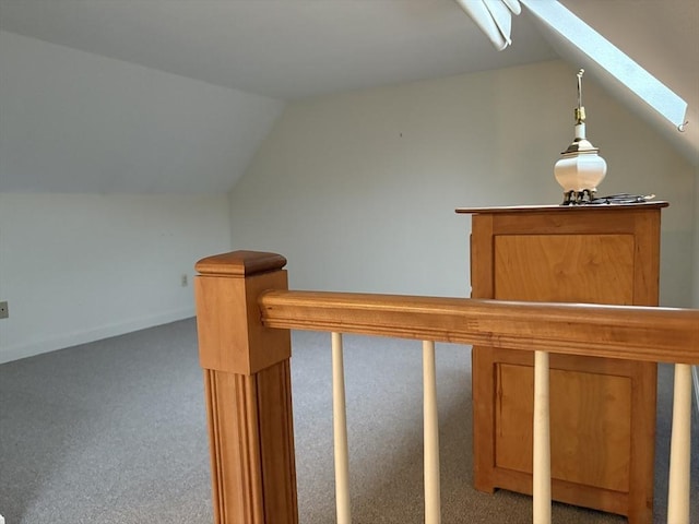 stairway featuring lofted ceiling with skylight and carpet flooring