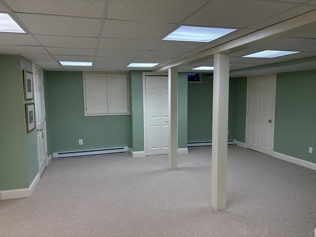 basement with a paneled ceiling, light carpet, and baseboard heating