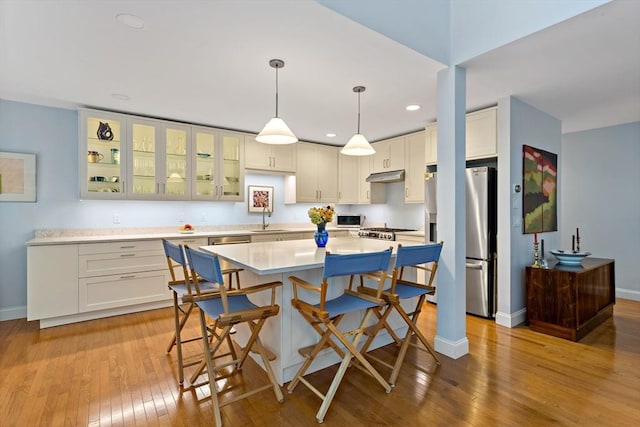 15 Berrywood Ct Unit 15, Bourne, MA 02532 - kitchen with a kitchen island, baseboards, a kitchen breakfast bar, stainless steel refrigerator with ice dispenser, and hardwood / wood-style flooring