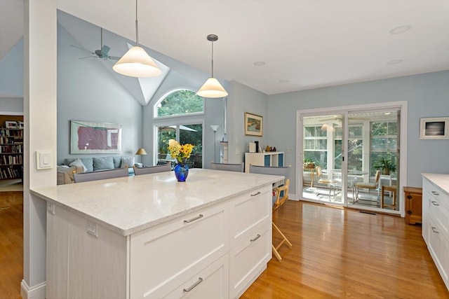 15 Berrywood Ct Unit 15, Bourne, MA 02532 - kitchen featuring light wood finished floors, ceiling fan, lofted ceiling, and white cabinetry
