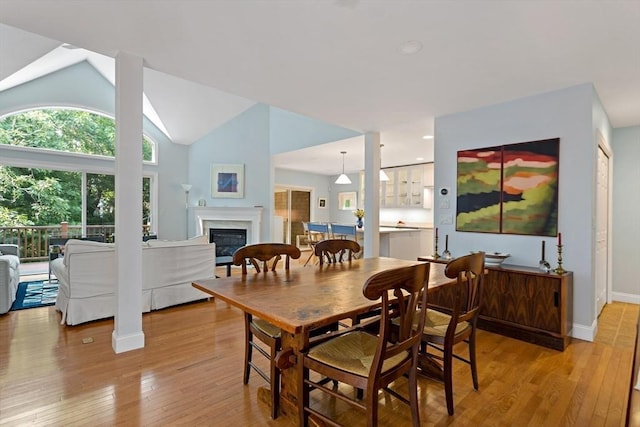15 Berrywood Ct Unit 15, Bourne, MA 02532 - dining space with a glass covered fireplace, baseboards, vaulted ceiling, and light wood finished floors