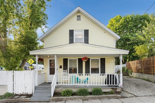 view of front of house with covered porch and fence