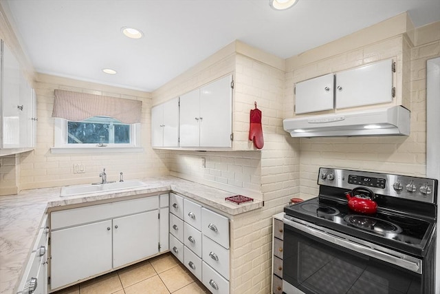 kitchen featuring stainless steel electric range, a sink, under cabinet range hood, white cabinetry, and light countertops