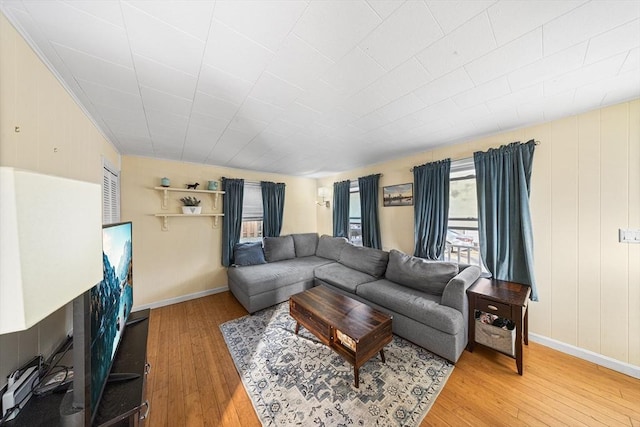 living room with healthy amount of natural light, hardwood / wood-style floors, and baseboards