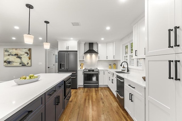 315 Maple Ave, Shrewsbury, MA 01545 - kitchen featuring stainless steel appliances, a sink, wall chimney exhaust hood, white cabinets, and recessed lighting