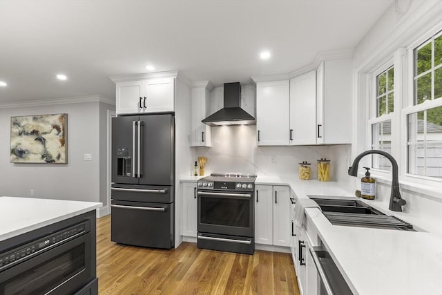 315 Maple Ave, Shrewsbury, MA 01545 - kitchen with high end refrigerator, wall chimney exhaust hood, range with electric cooktop, a sink, and white cabinetry