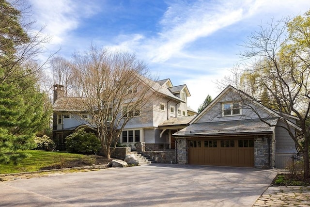 shingle-style home with stone siding and aphalt driveway