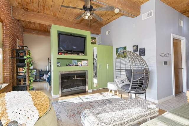 living room featuring wooden ceiling, ceiling fan, light wood-type flooring, a towering ceiling, and beam ceiling