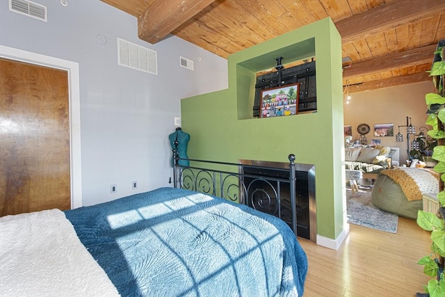 bedroom with vaulted ceiling with beams, hardwood / wood-style floors, and wooden ceiling