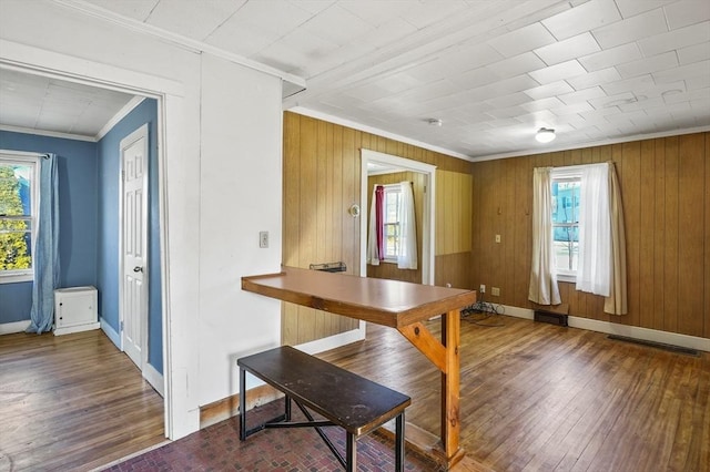 dining room featuring wooden walls and ornamental molding