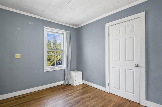 empty room featuring ornamental molding and hardwood / wood-style floors