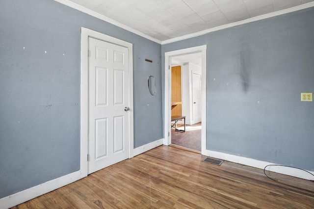 unfurnished bedroom featuring ornamental molding and hardwood / wood-style floors