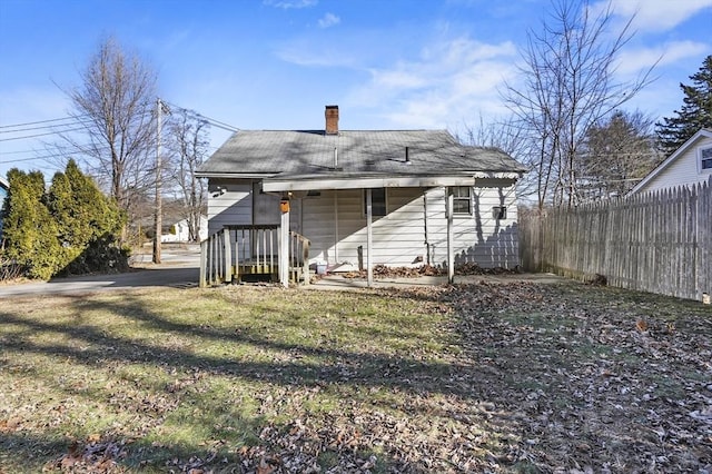 rear view of house featuring a yard