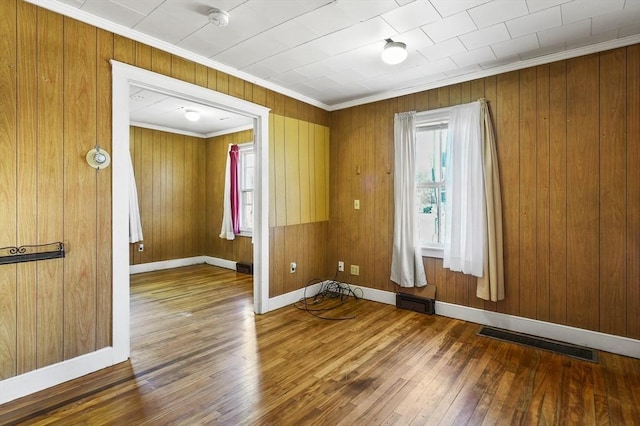 unfurnished room featuring hardwood / wood-style flooring and crown molding