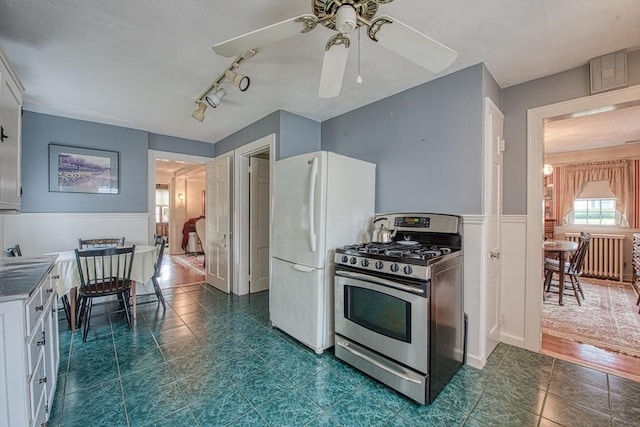 27 Carrlyn Rd, Brockton, MA 02301 - kitchen with white cabinets, freestanding refrigerator, a ceiling fan, stainless steel range with gas cooktop, and wainscoting