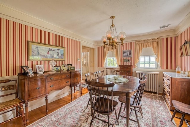 27 Carrlyn Rd, Brockton, MA 02301 - dining room featuring crown molding, radiator, an inviting chandelier, wood finished floors, and wallpapered walls