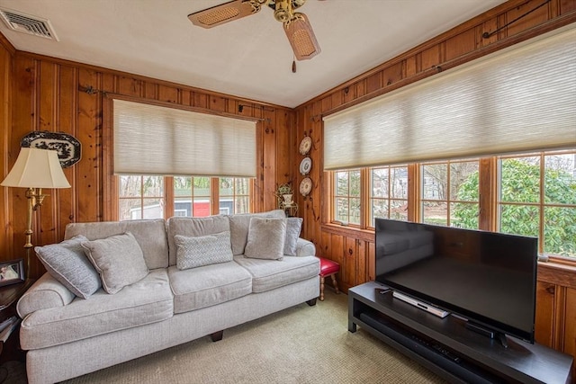 27 Carrlyn Rd, Brockton, MA 02301 - living area with visible vents, ceiling fan, light colored carpet, and wood walls