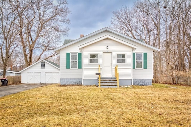 bungalow featuring entry steps, a front yard, fence, and an outdoor structure