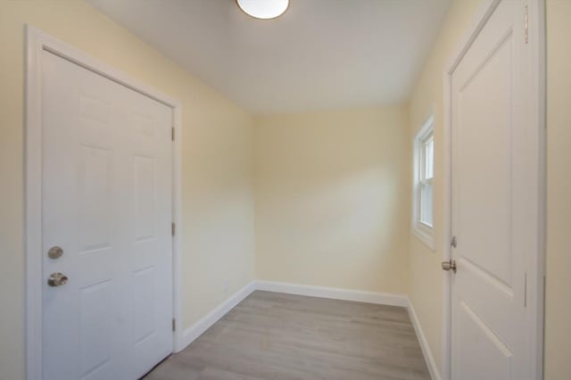 doorway to outside with light wood-type flooring and baseboards