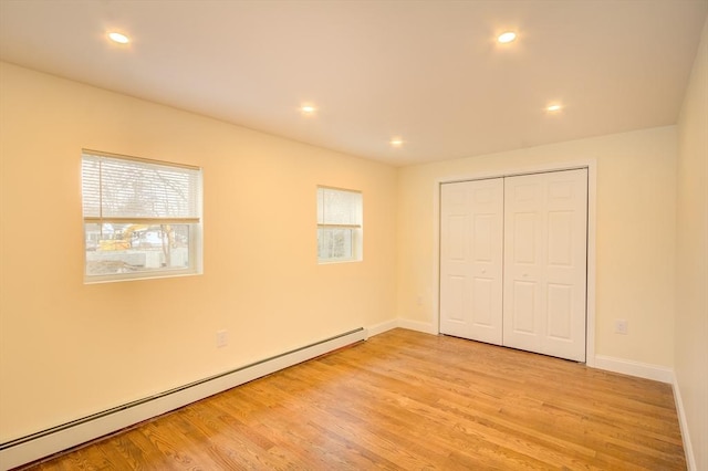 unfurnished bedroom featuring light wood-style floors, a baseboard radiator, and recessed lighting