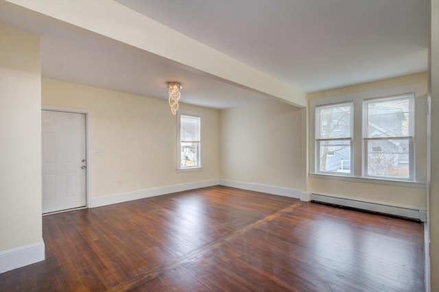 unfurnished room featuring baseboard heating, wood finished floors, and baseboards