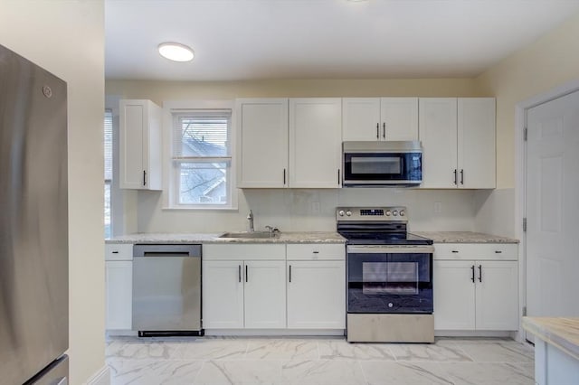 kitchen with white cabinets, marble finish floor, stainless steel appliances, and a sink