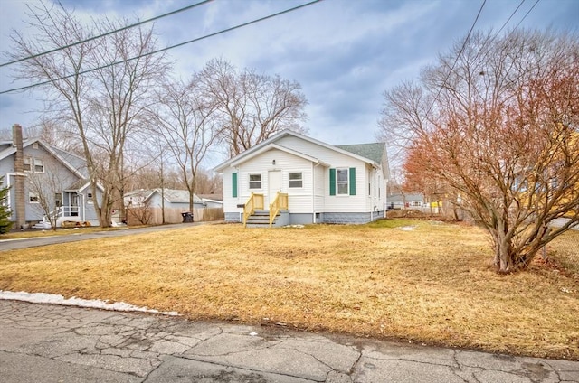 bungalow-style house with a front yard and fence