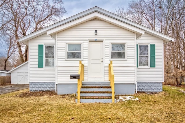 bungalow with entry steps, fence, and a front lawn