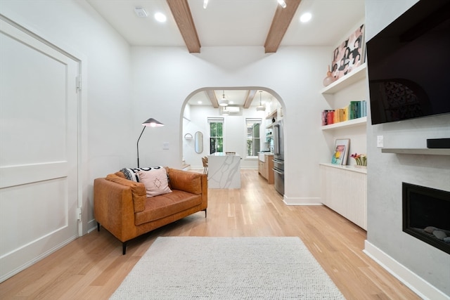 sitting room featuring beam ceiling and light wood-type flooring