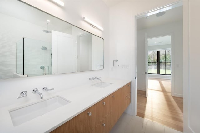 bathroom featuring hardwood / wood-style floors, vanity, and tiled shower