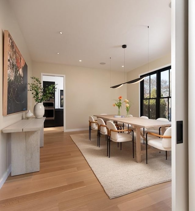 dining space featuring french doors and light wood-type flooring