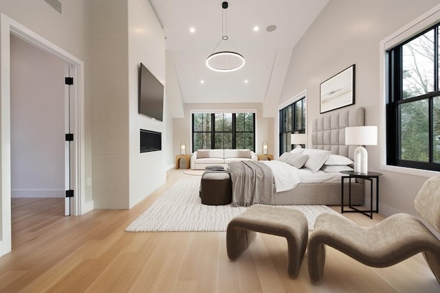 bedroom featuring high vaulted ceiling and light wood-type flooring