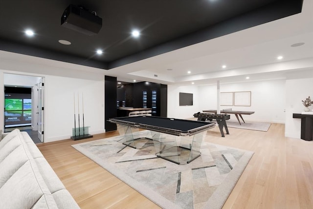 recreation room featuring a tray ceiling, pool table, and light hardwood / wood-style flooring